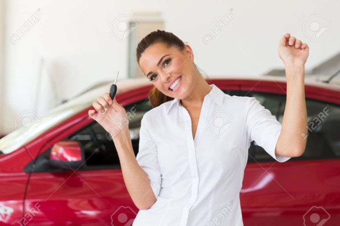 young woman collecting her new car from dealership